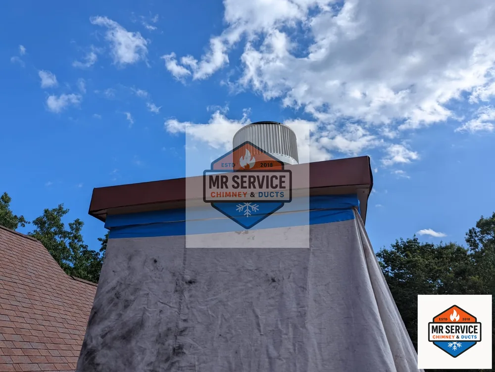 Chimney top viewed against a blue sky during exterior work
