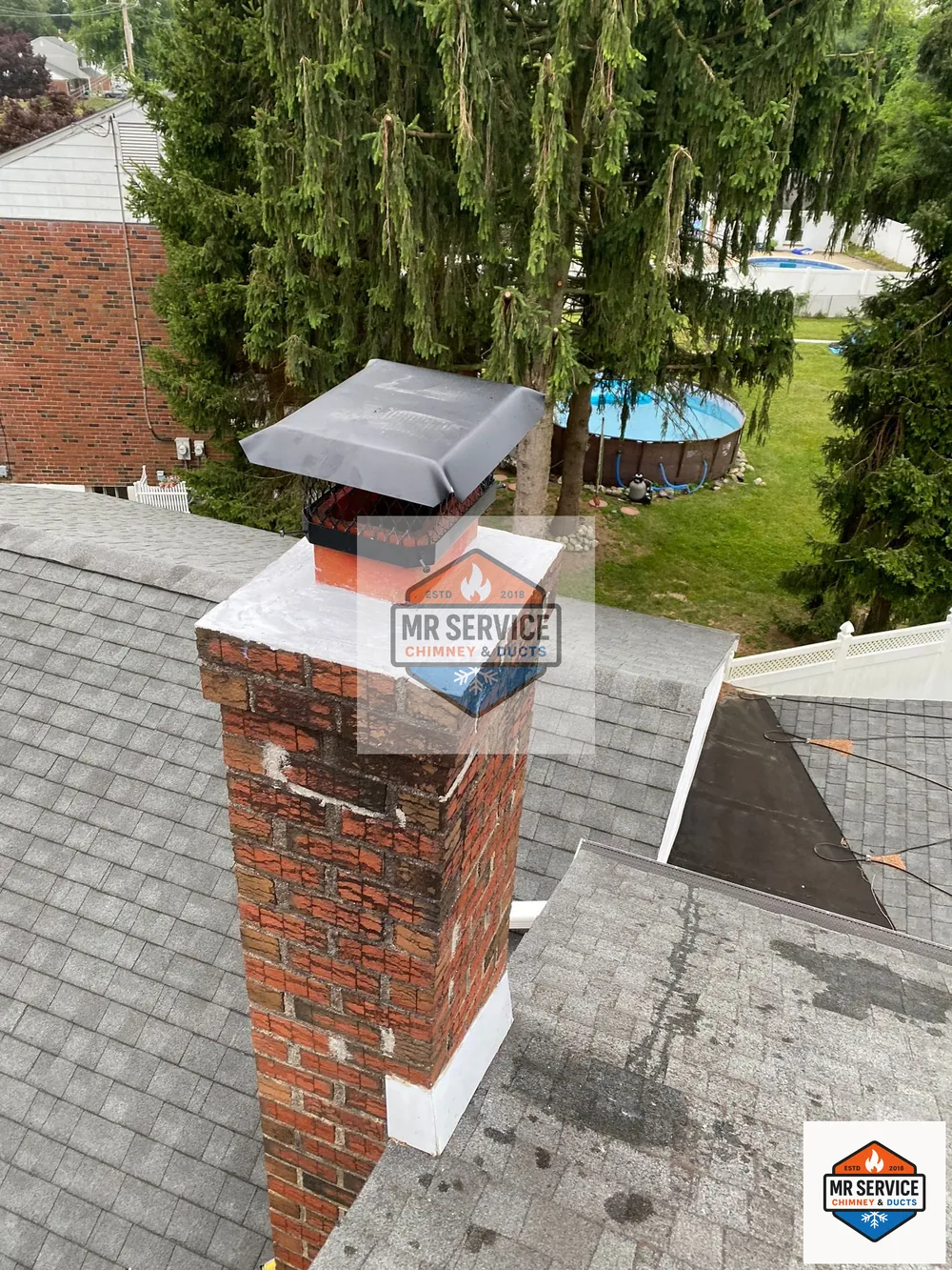 Residential chimney cap installation on a brick chimney